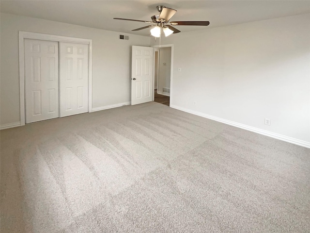 unfurnished bedroom featuring a closet, visible vents, carpet flooring, ceiling fan, and baseboards