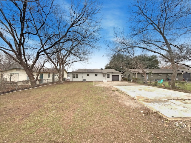 view of yard with a residential view, driveway, an attached garage, and fence