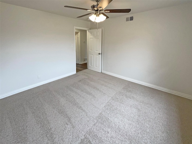 spare room with carpet floors, baseboards, visible vents, and ceiling fan