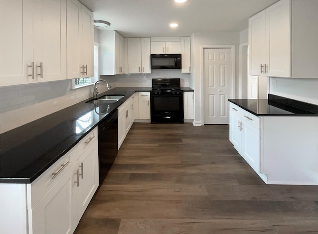 kitchen with dark countertops, white cabinets, a sink, and black appliances