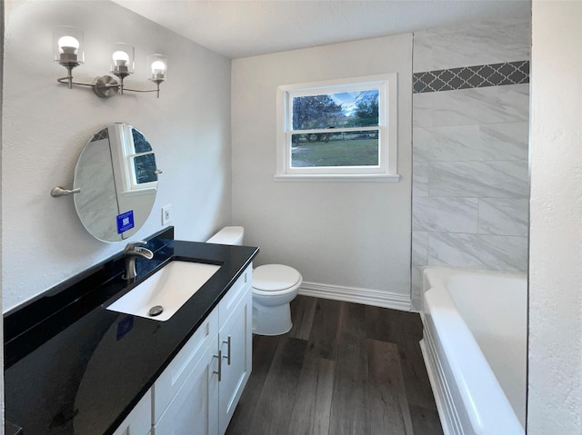 bathroom featuring toilet, vanity, shower / tub combination, wood finished floors, and baseboards