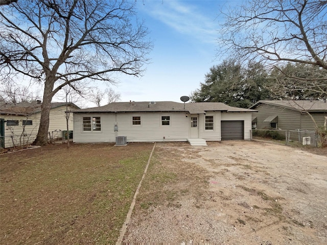 back of property featuring a garage, a yard, fence, and central air condition unit