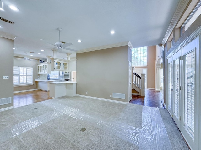 unfurnished living room featuring stairway, visible vents, and crown molding