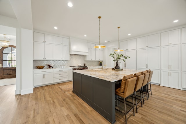 9514 Still Creek Ln, Dallas, TX 75238 - kitchen featuring premium range hood, light wood finished floors, white cabinets, decorative backsplash, and recessed lighting