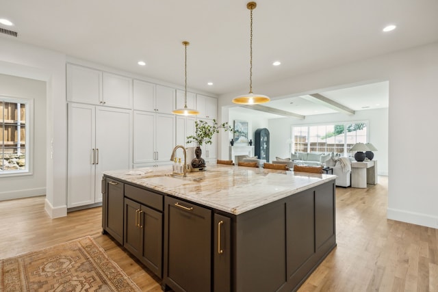 9514 Still Creek Ln, Dallas, TX 75238 - kitchen featuring a sink, light wood finished floors, white cabinets, light stone countertops, and recessed lighting