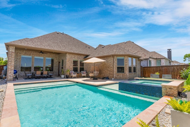 view of swimming pool with a pool with connected hot tub, fence, a ceiling fan, and a patio