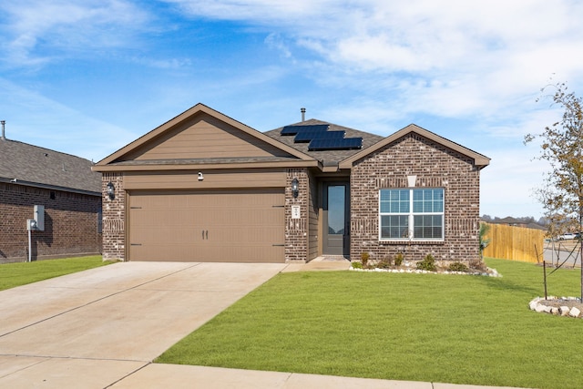 view of front of property with brick siding, a front yard, fence, and roof mounted solar panels