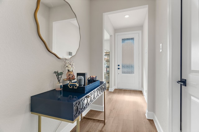 doorway featuring baseboards and wood finished floors