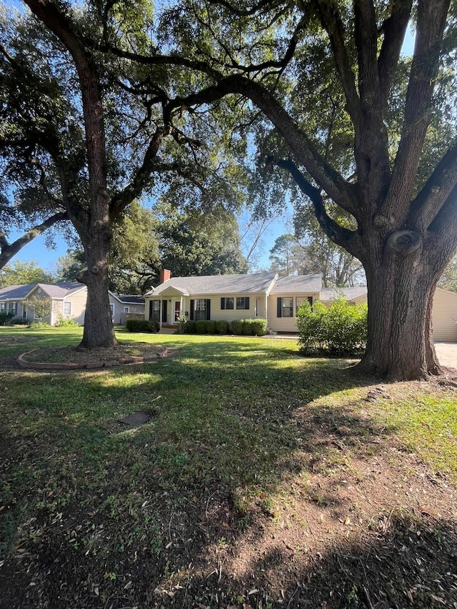 view of front facade with a front lawn and a chimney