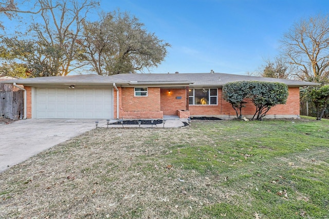 single story home featuring an attached garage, a front yard, concrete driveway, and brick siding