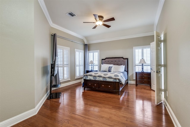 bedroom featuring crown molding, visible vents, dark wood-type flooring, a ceiling fan, and baseboards