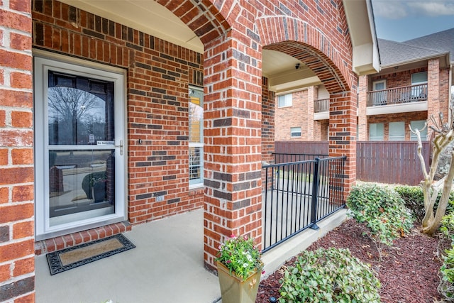 property entrance with brick siding and a shingled roof