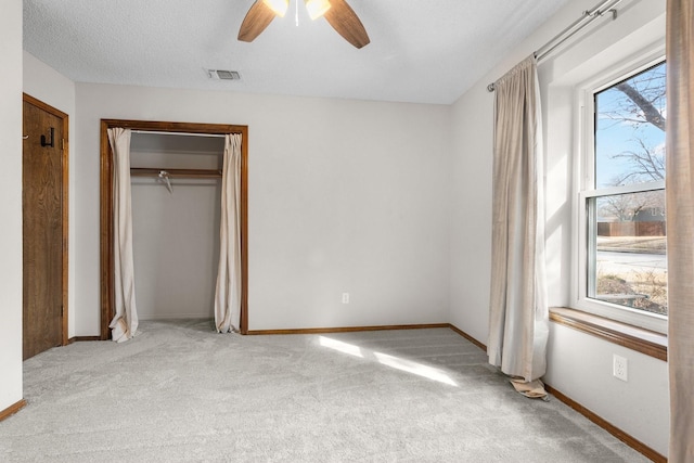 unfurnished bedroom with light carpet, multiple windows, visible vents, and baseboards