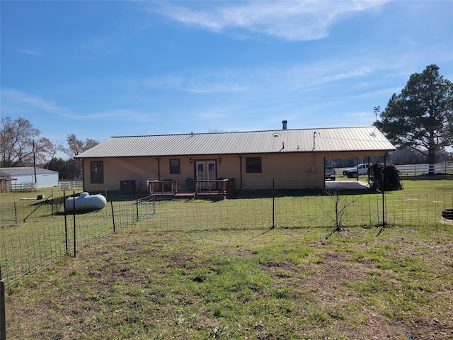 back of property with a yard, french doors, fence, and metal roof