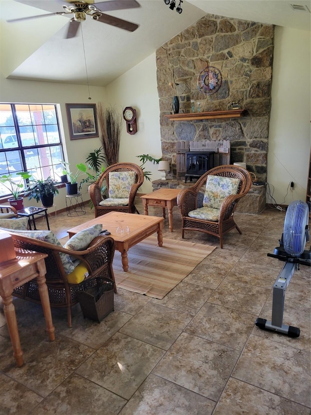 sitting room with a fireplace, vaulted ceiling, visible vents, and ceiling fan