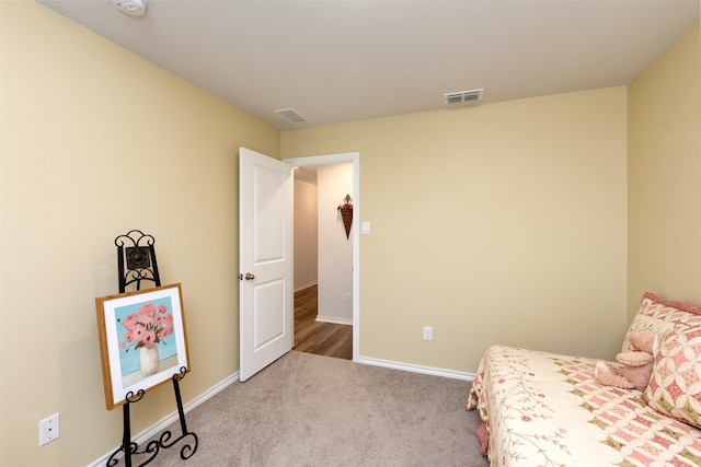 bedroom featuring visible vents, light carpet, and baseboards