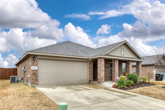 ranch-style house featuring an attached garage, driveway, brick siding, and central AC unit