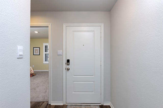 doorway to outside with baseboards and wood finished floors