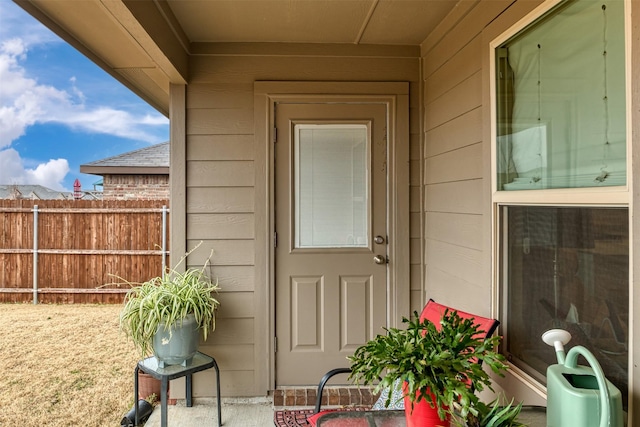 view of exterior entry featuring fence