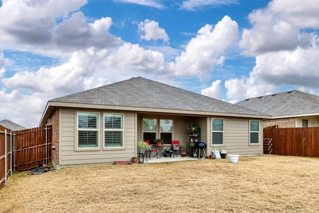 back of property featuring a patio, roof with shingles, and a fenced backyard