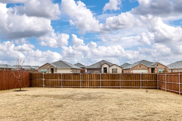 view of yard with a fenced backyard and a residential view