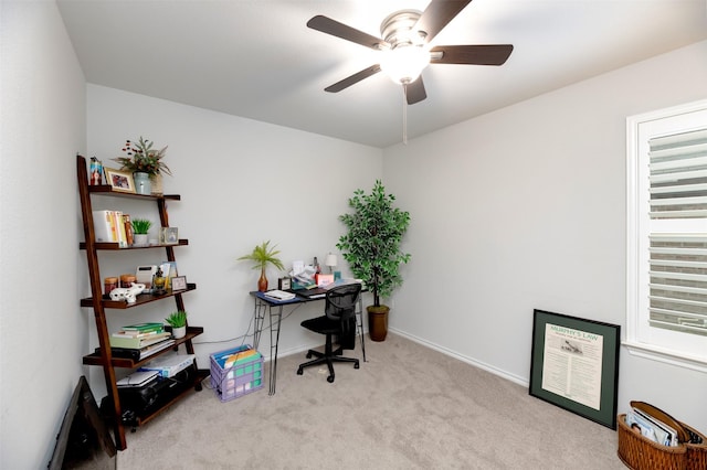 office area with a ceiling fan, light carpet, and baseboards