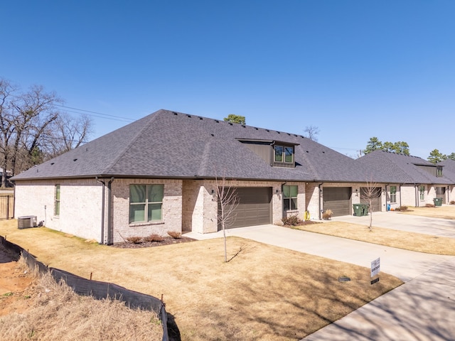14195 County Road 192, Tyler, TX 75703 - view of front of house featuring concrete driveway, brick siding, a garage, cooling unit, and a shingled roof