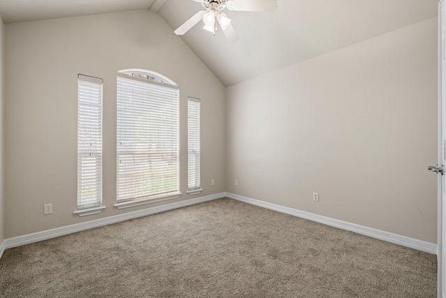 carpeted empty room with a ceiling fan, vaulted ceiling, and baseboards