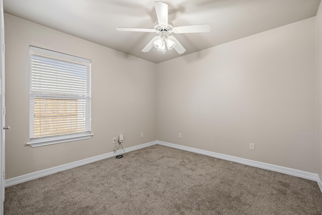 spare room with a ceiling fan, carpet flooring, and baseboards