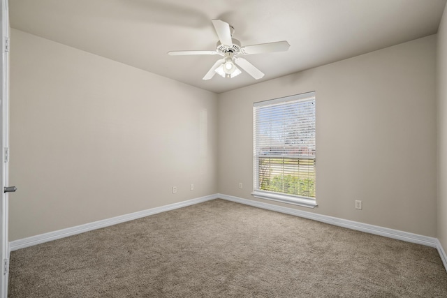 carpeted empty room with baseboards and a ceiling fan