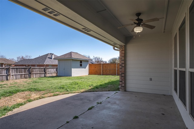 view of patio / terrace featuring a ceiling fan, a fenced backyard, an outdoor structure, and a shed