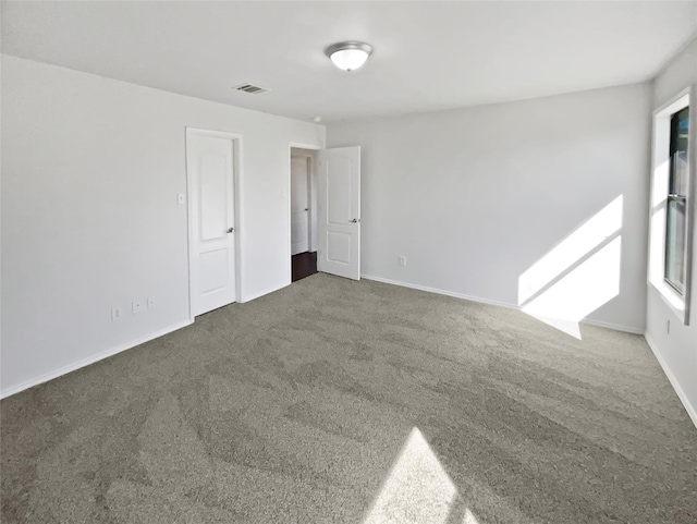 unfurnished room featuring baseboards, visible vents, and carpet flooring