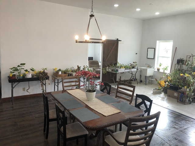 dining room with dark wood-style floors, recessed lighting, baseboards, and a barn door