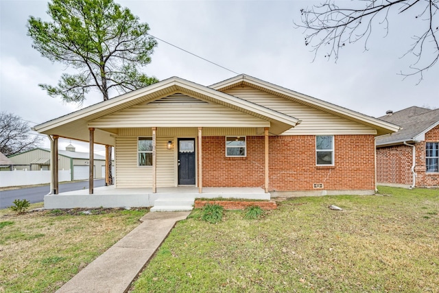 bungalow-style home with a porch, a front yard, and brick siding