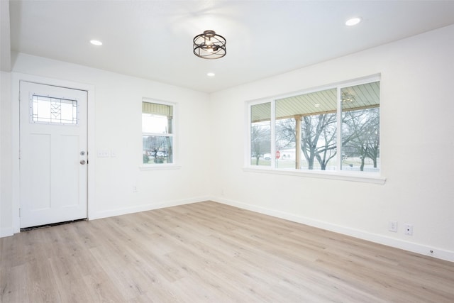 foyer featuring light wood-type flooring, a wealth of natural light, and recessed lighting