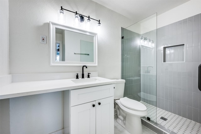 bathroom with toilet, a shower stall, and vanity