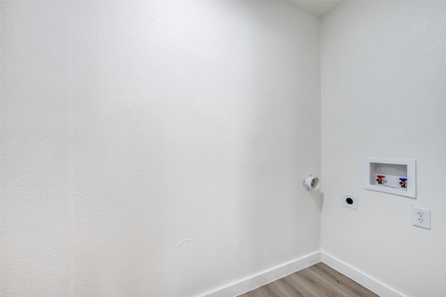 clothes washing area with hookup for a washing machine, laundry area, wood finished floors, baseboards, and electric dryer hookup