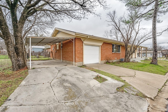 view of side of home featuring brick siding, a yard, an attached garage, a carport, and driveway