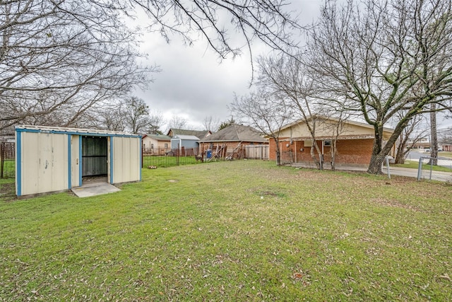 view of yard with an outbuilding, fence, and a storage shed