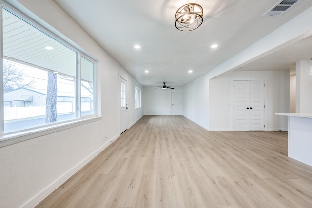 empty room with light wood finished floors, baseboards, visible vents, and ceiling fan