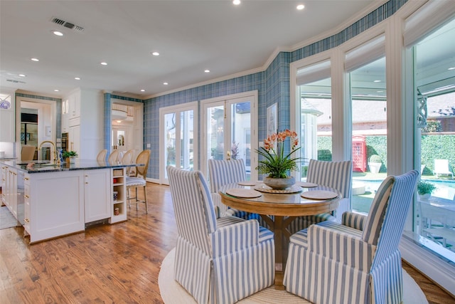 dining space with recessed lighting, visible vents, ornamental molding, light wood-type flooring, and wallpapered walls