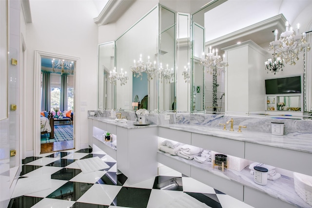 ensuite bathroom with tile patterned floors, connected bathroom, an inviting chandelier, and vanity