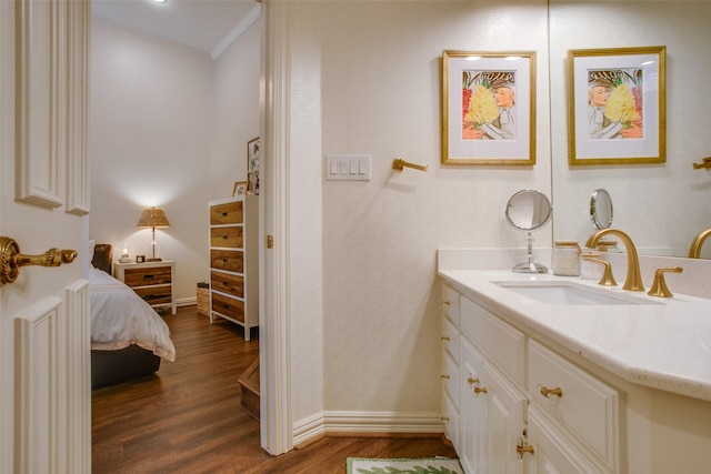 ensuite bathroom with ensuite bathroom, wood finished floors, vanity, and wallpapered walls