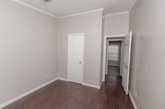 unfurnished bedroom with crown molding, dark wood finished floors, a textured ceiling, and baseboards