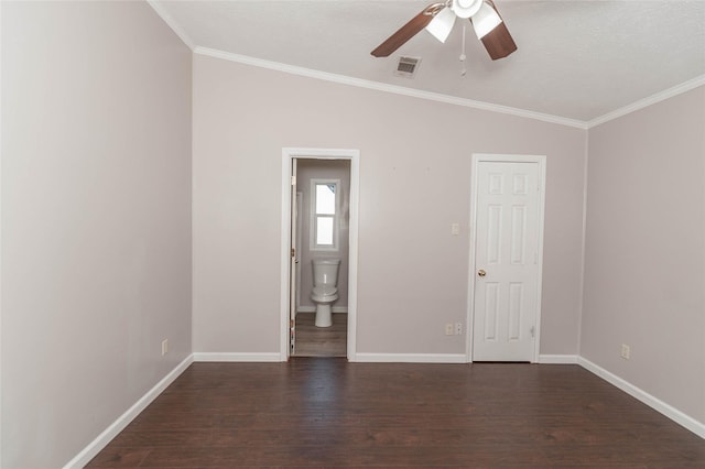 unfurnished bedroom featuring ornamental molding, visible vents, dark wood finished floors, and baseboards