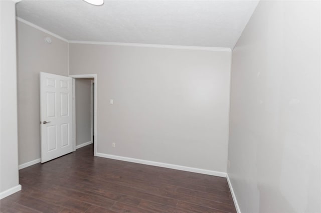 unfurnished room featuring dark wood-style floors, lofted ceiling, crown molding, and baseboards