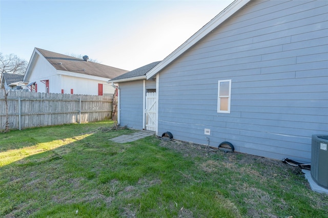 back of property with fence, cooling unit, and a yard