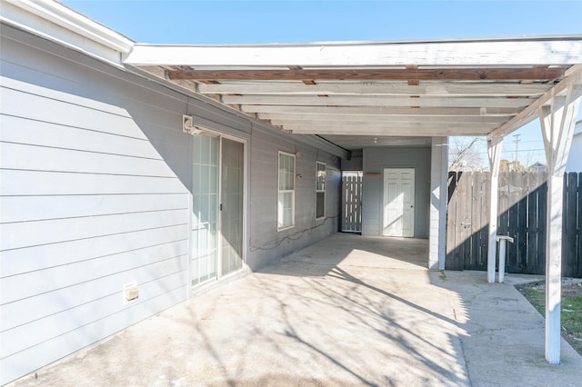 view of parking / parking lot featuring a carport and fence