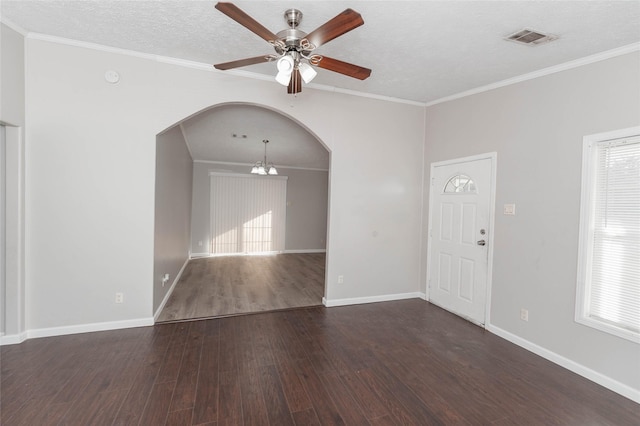 unfurnished room featuring arched walkways, a textured ceiling, visible vents, ornamental molding, and dark wood finished floors