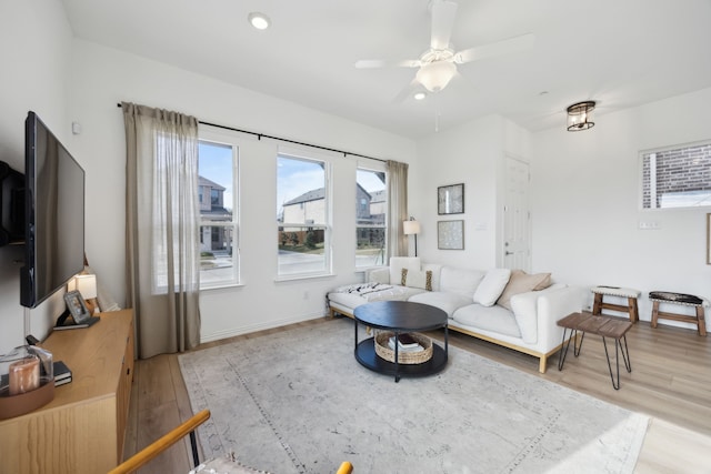 living room featuring light wood-style floors, ceiling fan, baseboards, and recessed lighting